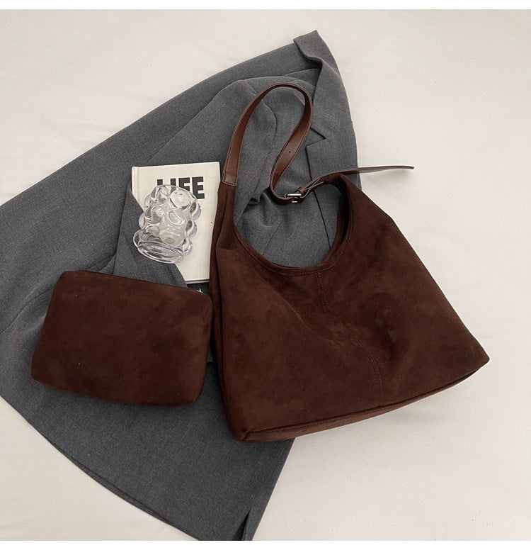brown large women's hobo shoulder bag and toiletry bag in a lifestyle flat lay
